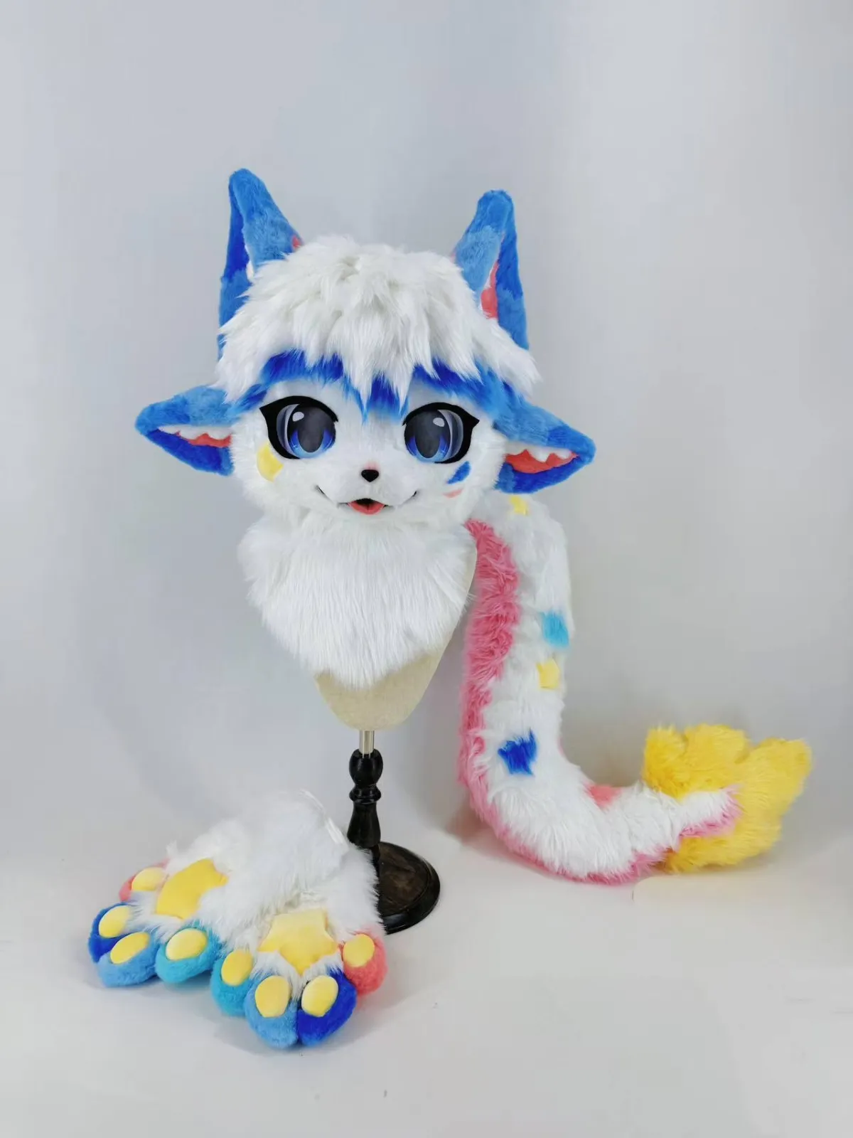 Blue & white fox fursuit with rainbow tail and paws
