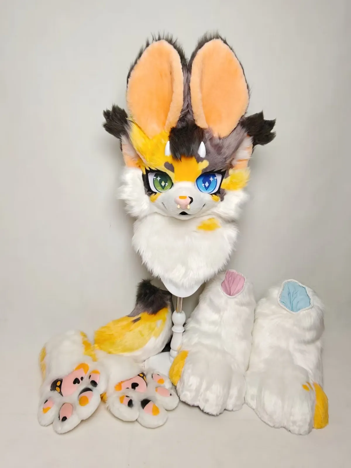 Orange-eared calico fursuit with heterochromia