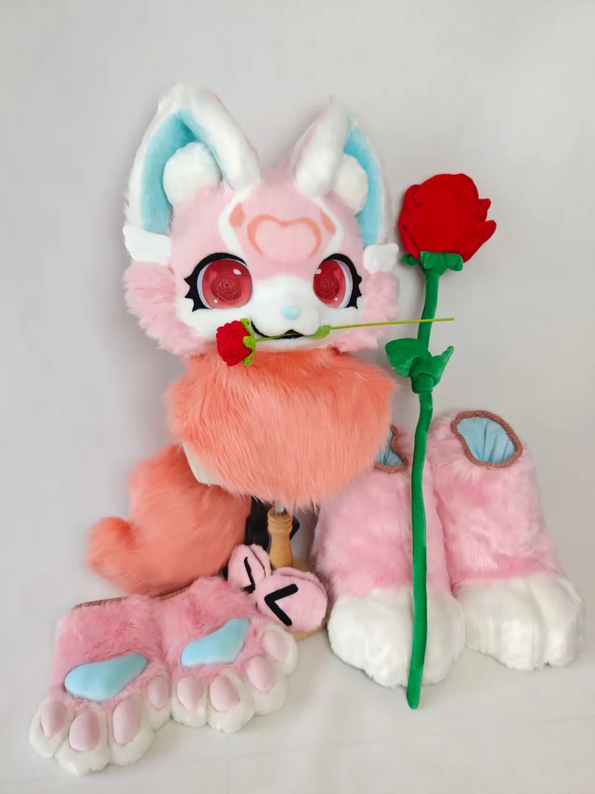Pink & blue bunny-eared fursuit holding a rose